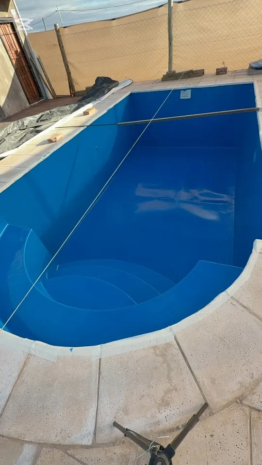 Vaso de una piscina pintado de azul, con las cintas de protección todavía puestas en los bordes